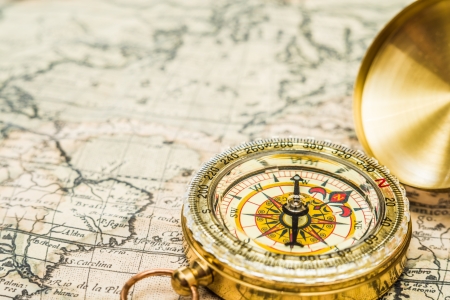 compass and magnifying glass gold color on the old map with coinsの写真素材