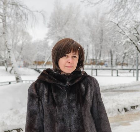 middle-aged woman in a mink coat against winterの写真素材