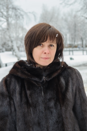 middle-aged woman in a mink coat against winterの写真素材