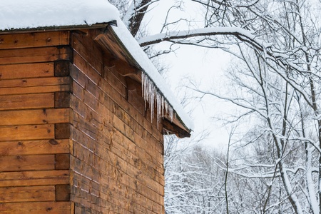roof of the house with snow and icicles hangingの写真素材