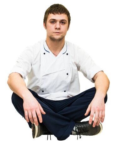 a young man sitting cross-legged on a white backgroundの写真素材