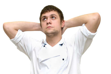 young guy sits his hands raised over his headの写真素材