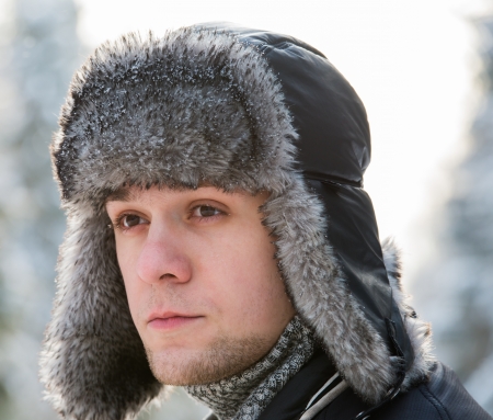a man in a fur winter hat with ear flapsの写真素材