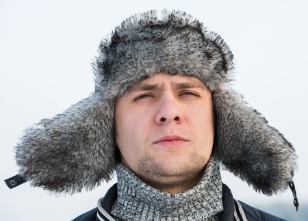 a man in a fur winter hat with ear flapsの写真素材