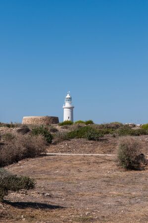 Coast white lighthouse against a blue sky on the island of Cyprusの写真素材