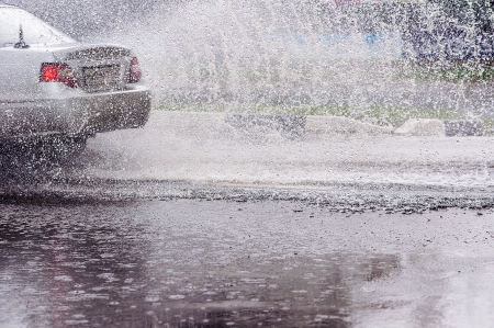 Car rides on big water in the rainの写真素材