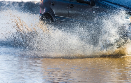 Car rides on big water in the rainの写真素材