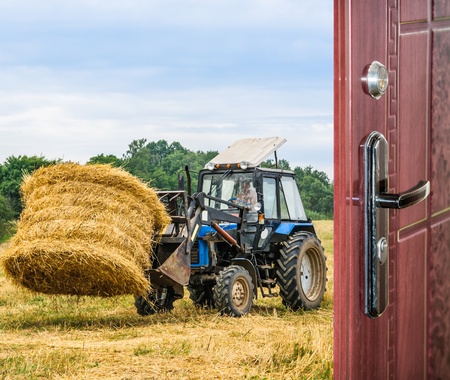 tractor removes the hay the view through the open doorの写真素材