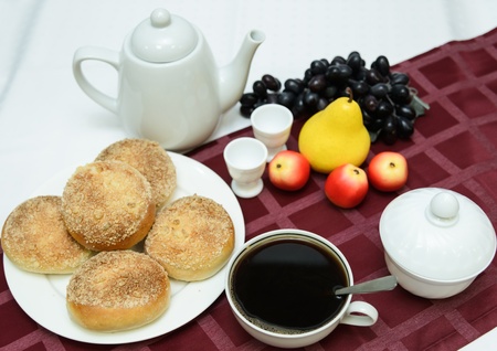 cup of hot tea with buns on a table covered with a tableclothの写真素材