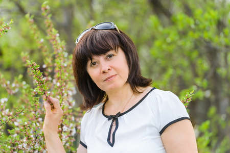 portrait of a middle-aged brunette woman on a background of natureの写真素材