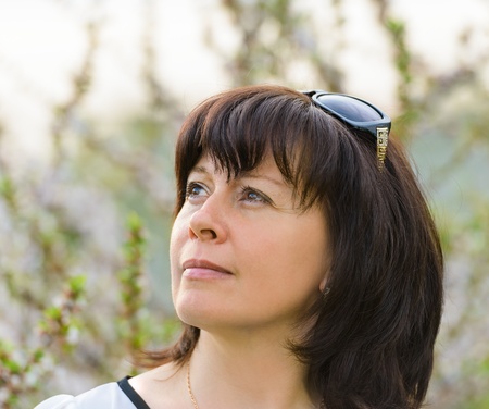 portrait of a middle-aged brunette woman on a background of natureの写真素材