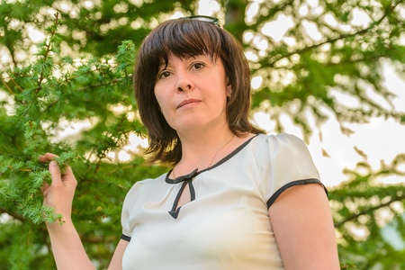 portrait of a middle-aged brunette woman on a background of natureの写真素材