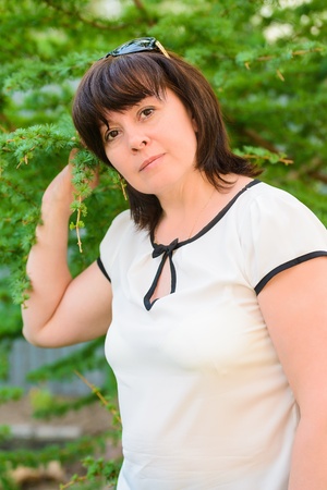 portrait of a middle-aged brunette woman on a background of natureの写真素材