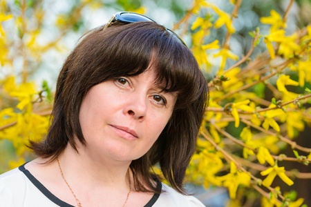 portrait of a middle-aged brunette woman on a background of natureの写真素材
