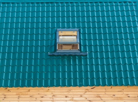 green tile roof house with a built-in windowの写真素材