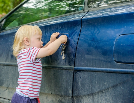 little kid wants to open a car door keyの写真素材