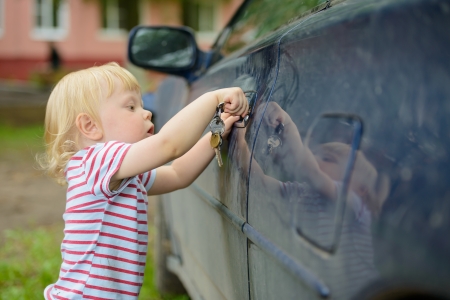 little kid wants to open a car door keyの写真素材