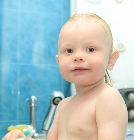 small red-haired boy is bathed in the showerの写真素材