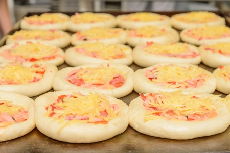 prepared for baking on a baking mini pizza with cheeseの写真素材