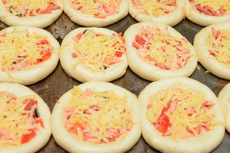prepared for baking on a baking mini pizza with cheeseの写真素材