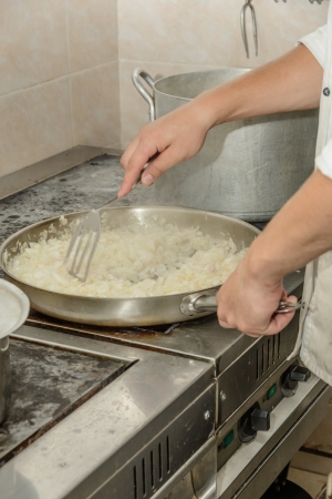 cooking fried onions chopped slices in a frying panの写真素材