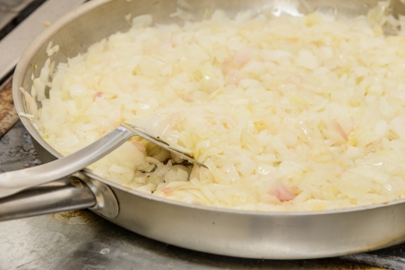 cooking fried onions chopped slices in a frying panの写真素材