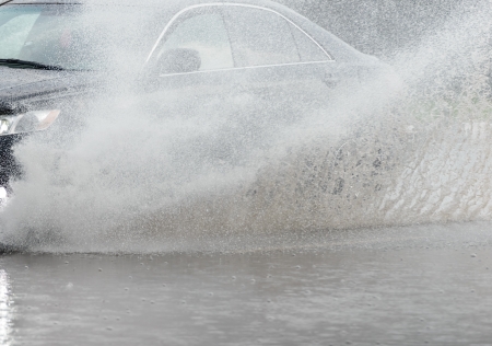 Car rides on big water in the rainの写真素材