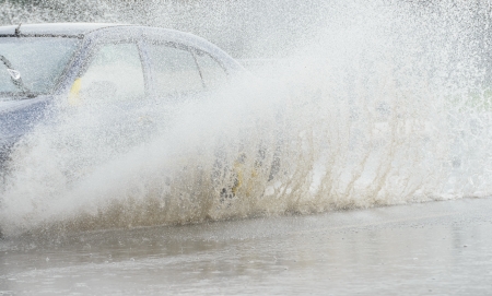 Car rides on big water in the rainの写真素材