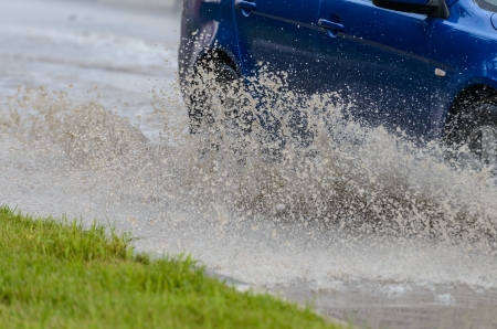 Car rides on big water in the rainの写真素材