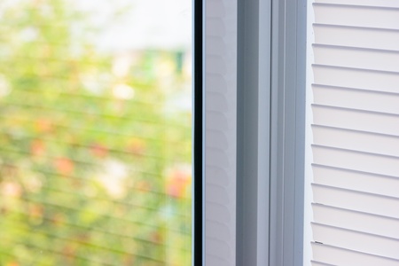 closed plastic blinds on the window with the reflection in the glassの写真素材