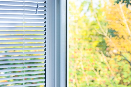closed plastic blinds on the window with the reflection in the glassの写真素材