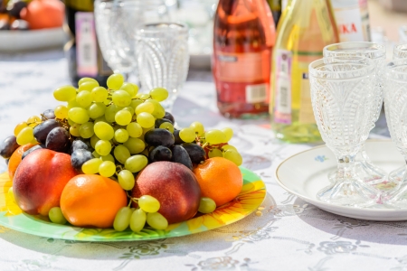 grape apple kiwi strawberry lie in a vase close upの写真素材