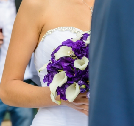 bride in a white dress holding a wedding bouquet of flowersの写真素材