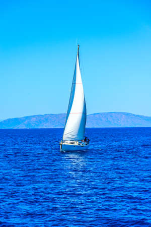 sailing boat floating in the sea near the shoreの写真素材