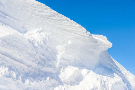 big snow hummock of pure white snow on a background of blue skyの写真素材