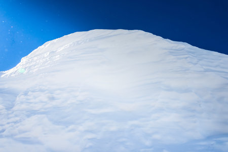 big snow hummock of pure white snow on a background of blue sky
