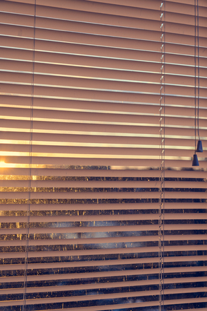 closed plastic blinds on the window with the reflection in the glassの写真素材