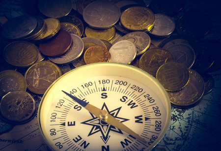 compass and magnifying glass gold color on the old map with coinsの写真素材