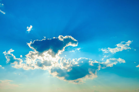sun with clouds against the blue sky