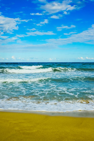 sandy beach and calm blue sea surf