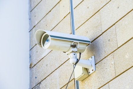 video surveillance camera hanging on the wall of a building