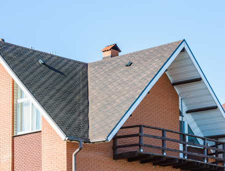 chimney on the roof of the house against the blue skyの写真素材