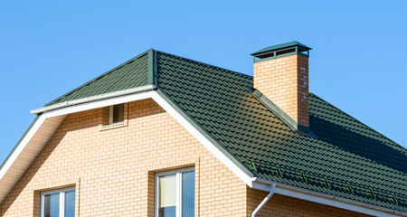 chimney on the roof of the house against the blue skyの写真素材