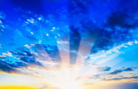 Decline in clouds of the sun with beams backgroundの写真素材