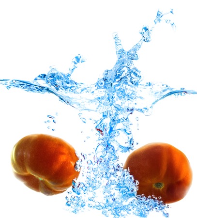 isolated ripe tomatoes in water with bubbles of airの写真素材