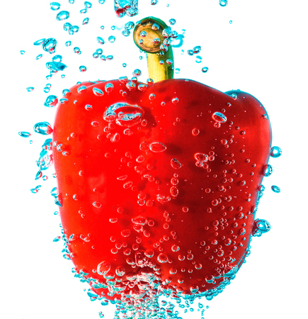 sweet pepper falling in water with splashes and dropsの写真素材