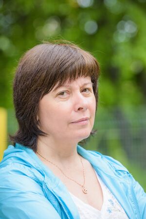 portrait of a middle-aged brunette woman on a background of natureの写真素材