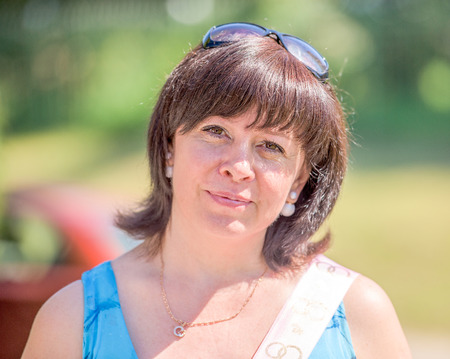 portrait of a middle-aged brunette woman on a background of natureの写真素材