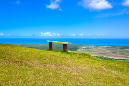 wooden bench on a hilltop overlooking the horizonの写真素材