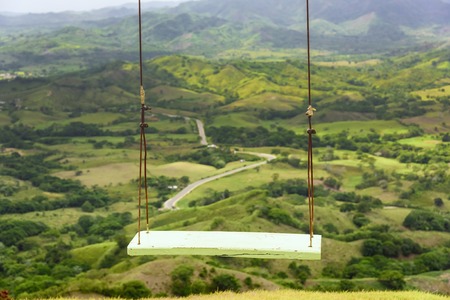 yellow wooden swing on the ropes for funの写真素材